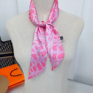 Detailweergave van een roze en paarse zijden sjaal geknoopt in een strik met patronen
