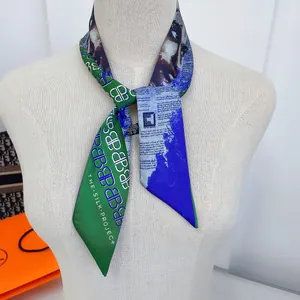 Dettaglio di una sciarpa alla moda con stampa di giornale e motivi geometrici su un manichino