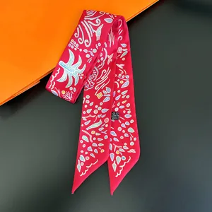 Macro detail of red polyester narrow scarf showing abstract patterns and fabric labels