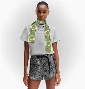 Floral print green silk skinny scarf styled on a model with modern casual outfit