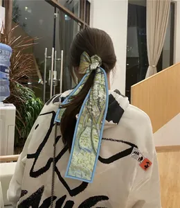 Détail d'un ruban en soie aux motifs artistiques noué sur une queue de cheval