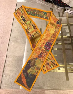 Artistic long silk scarf detail with orange hem and Gustav Klimt style print pattern