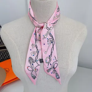 Detailed shot of pink twilly scarf with key patterns tied on a mannequin neck