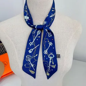 Detail of dark blue silk twilly featuring vintage key patterns tied on a white mannequin