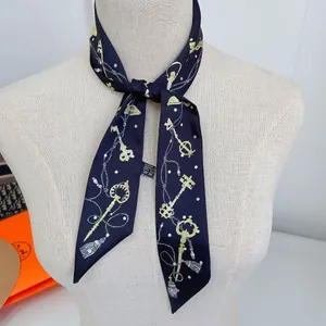 Detail view of navy silk twilly scarf with gold key pattern tied on a handle