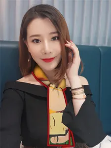 Artistic floral silk scarf worn as a necktie accent on a black off-shoulder top
