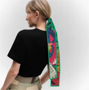 Artistic abstract print silk twilly scarf with green edges used as an elegant hair tie