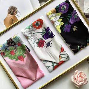 Detailed view of assorted floral and animal print silk scarves in a golden frame