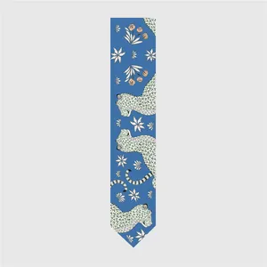 Detailed pattern of silk scarf featuring blue background with leopard and floral motifs