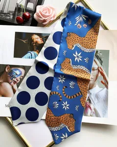 Detail of long silk scarf with leopard and polka dot prints on fashion magazine