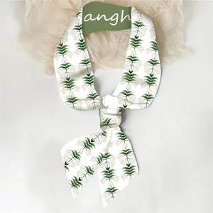 Detailopname van beige zijden sjaal met lelietjes-van-dalen bloemenprint in een knoop