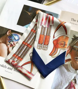 Detailed view of long silk scarf with equestrian horse harness prints on a fashion magazine