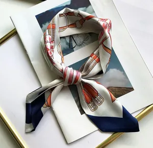 Detail of floral equestrian print silk scarf showing leather strap and bit patterns