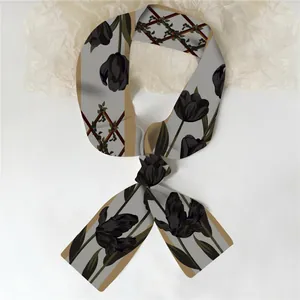Detail van de lange zijden sjaal met zwarte tulp bloemenprints en geometrische patronen