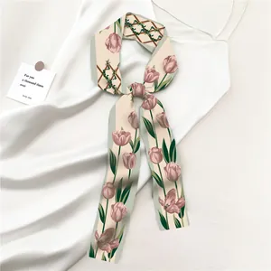 Detail van een lange zijden sjaal met tulpenprint gedrapeerd op witte zijden jurk