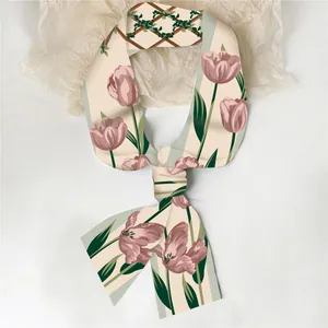 Detailopname van een satijnen twilly sjaal met elegante tulp- en traliewerkprint