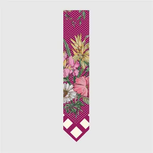 Detail of floral printed silk scarf with magenta polka dots and red plaid tips