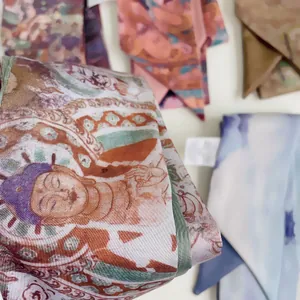Gedetailleerde macro-opname van zijden sjaal met vintage print en satijnachtige textuur