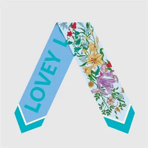 Close-up of double-sided silk scarf twilly with floral prints and blue letter patterns