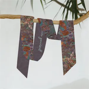 Detail van een smalle paarse Twilly sjaal met Chinese motieven op een houten takje