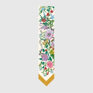 Detailed close-up of a floral silk twilly scarf with botanical print and yellow tips