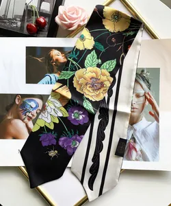 Detail showing double-sided floral pattern and 100 percent silk label on thin twilly scarf