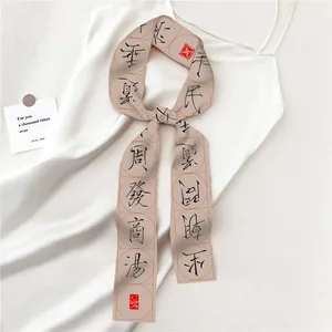 Detail van zijden twilly sjaal met zwarte Chinese kalligrafie en rode zegelprint