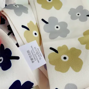 Detail van het 100% polyester label met zijdegevoel op een bloemige sjaal