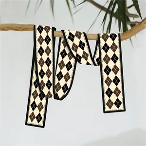 Detail van elegante zijden sjaal met ruitpatroon in bruine en beige tinten