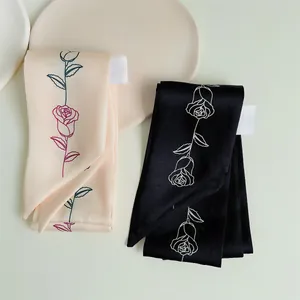 Detail van zijden sjaals met rozenpatroon in roze en zwart met premium twill textuur
