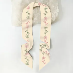 Detail van zijden sjaal met roze bloemenpatroon en elegante gestreepte schaduwen