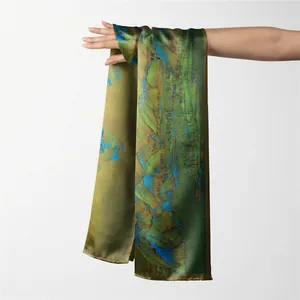 Détail d'un foulard en soie avec imprimé paysage artistique en vert olive et bleu