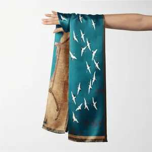 Détail d'un foulard en soie sarcelle orné de grues blanches et d'architecture traditionnelle