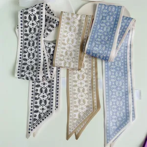 Detailopname van drie smalle zijden sjaals met paisley-print in diverse klassieke kleuren