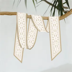 Detailopname van champagne paisley zijden sjaal gebonden aan een tak met puntige uiteinden