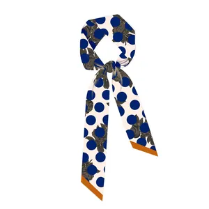 Detail van zijden sjaal met blauwe stippen, zwarte rozen en oranje rand in vintage