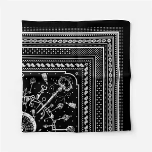 Detail of silk square scarf featuring black and white paisley and vintage key patterns