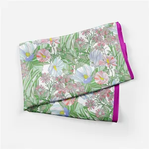 Close-up of floral pattern silk scarf with pink borders and green leaf detail