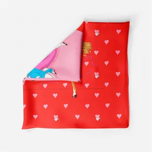 Detailed close-up of red silk scarf with pink heart patterns and stylized horse rider art
