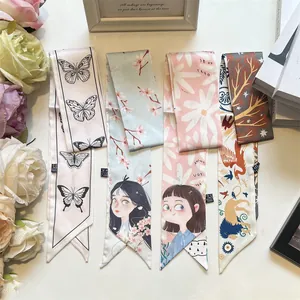 Flat lay of elegant twilly scarves with retro butterfly and floral prints on satin