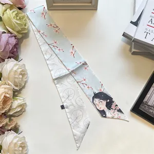 Close-up of narrow silk scarf featuring cherry blossom print and elegant floral details