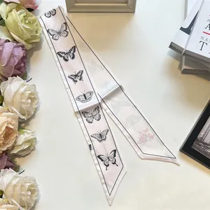 Detail of pink silk scarf with black butterfly print and diagonal pointed ends