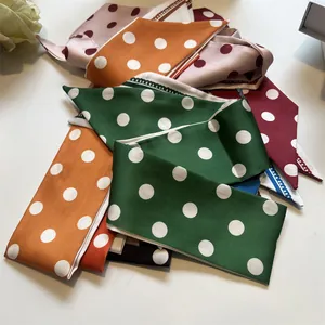 Dettaglio dei foulard in raso di seta con pois bianchi in vari colori dallo stile retrò