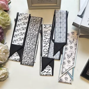 Detail showing elegant black and white silk twilly scarves with horse and flower patterns