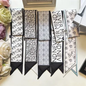 Flat lay of multiple black and white twilly scarves with assorted geometric and floral prints