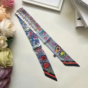 Close-up of elegant floral twilly scarf with stirrup patterns and decorative ribbons