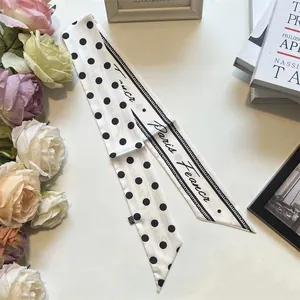 Dettaglio di un foulard in seta a pois francesi con scritta Paris France e fiori eleganti