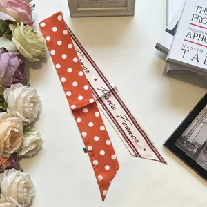 Dettaglio di un foulard sottile a pois double-face con scritte Paris France artistiche