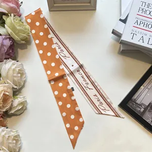 Dettaglio di sciarpa in seta retrò a pois con scritte Parigi e decorazioni floreali