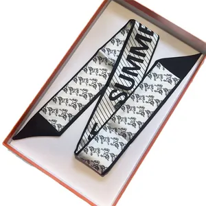 Elegant black and white silk twilly scarf with horse print and SUMMER logo in orange box
